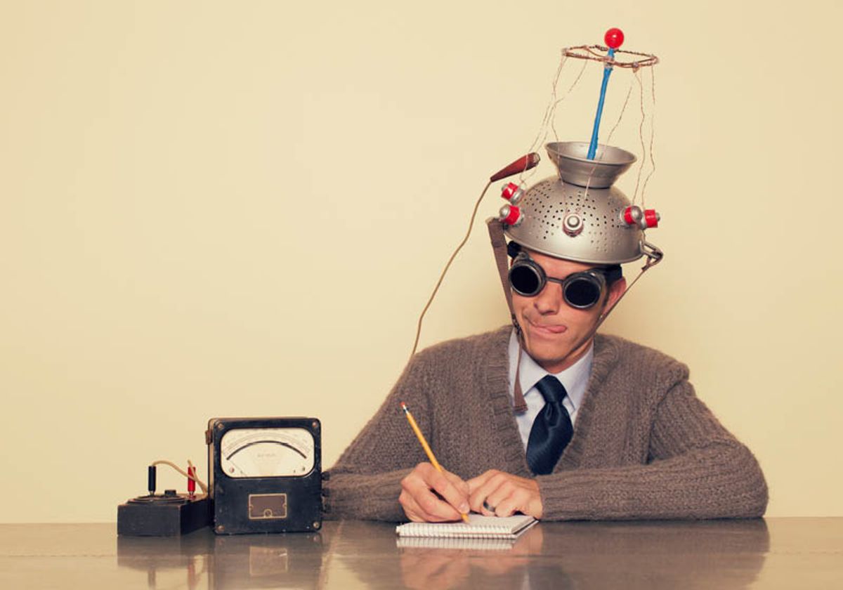 Conceptual retro image of a man wearing a silly mind reading gadget on his head, holding a pencil, and writing his thoughts down in a notebook. Conceptual retro image of a man wearing a silly mind reading gadget on his head, holding a pencil, and writing his thoughts down in a notebook.