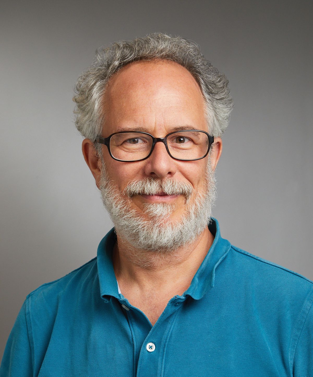 A man wear a blue polo shirt and glasses. A man wear a blue polo shirt and glasses.