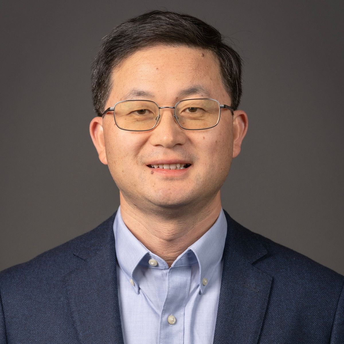 Headshot of bioengineer Liangfang Zhang. He smiles at the camera. He is wearing glasses and is wearing a light blue shirt under a dark blue jacket. Headshot of bioengineer Liangfang Zhang. He smiles at the camera. He is wearing glasses and is wearing a light blue shirt under a dark blue jacket.