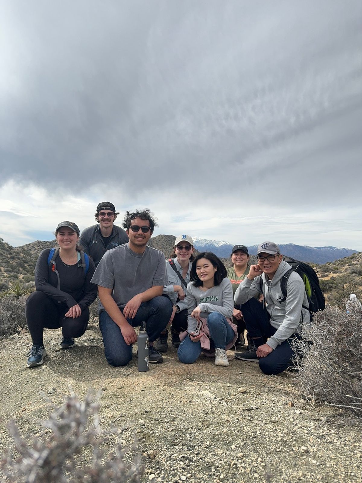 A group of people is surrounded by desert plants. A group of people is surrounded by desert plants.
