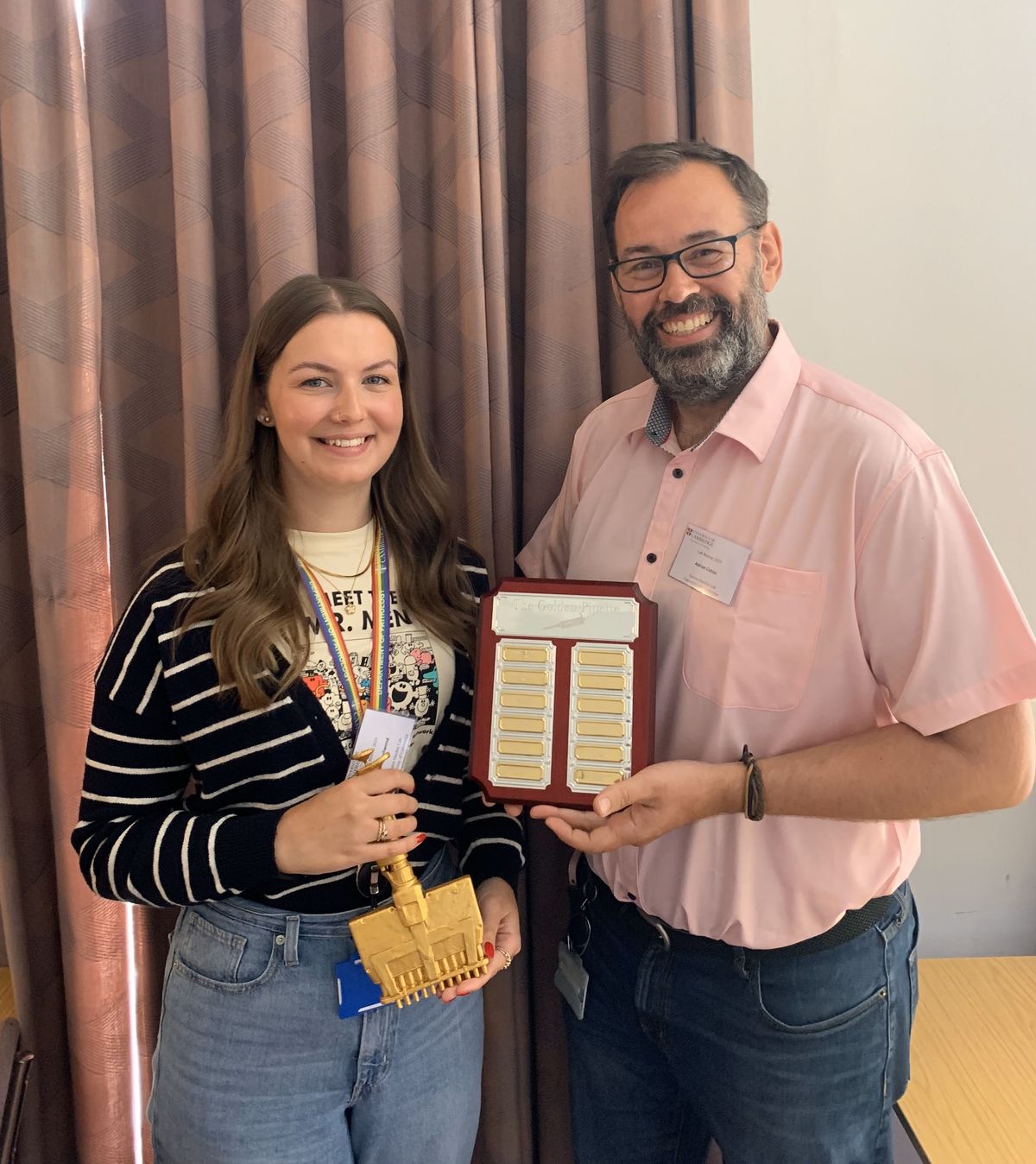 Photo of Amy Dashwood holding a golden multipipette and Adrian Liston holding an award plaque. Photo of Amy Dashwood holding a golden multipipette and Adrian Liston holding an award plaque.