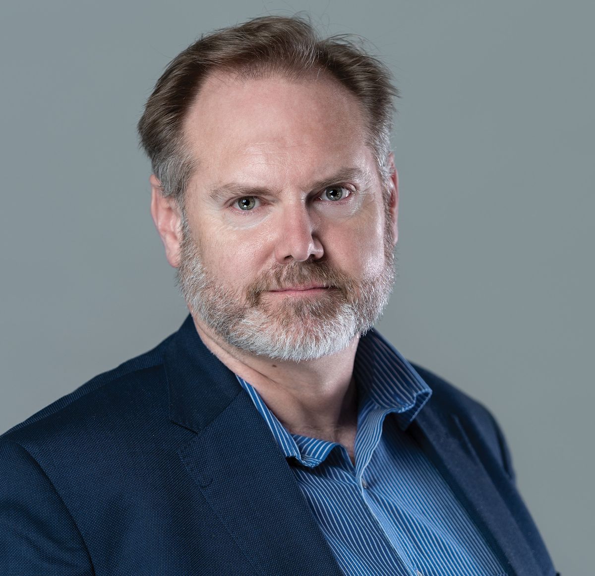 A man wears a blue shirt and jacket. A man wears a blue shirt and jacket.